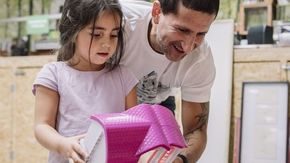 Liten jente viser faren sitt nye lekehus som hun har funnet på gjenbrukssatsjonen