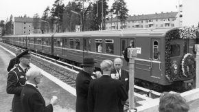 Svart-hvitt-bilde fra Bergkrystallen t-bane-stasjon. T-bane og folk som feirer åpningen.