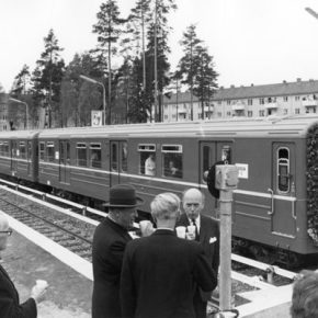 Svart-hvitt-bilde fra Bergkrystallen t-bane-stasjon. T-bane og folk som feirer åpningen.
