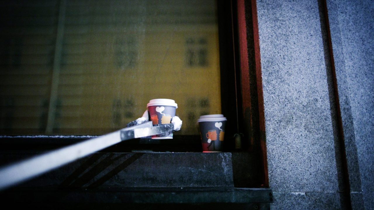 To tomme pappkaffekrus ryddes ned fra en vinduskarm.