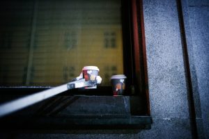 To tomme pappkaffekrus ryddes ned fra en vinduskarm.