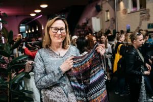 Tanja Aarsand holder fram en genser hun bytter til seg på Klesbyttedagen