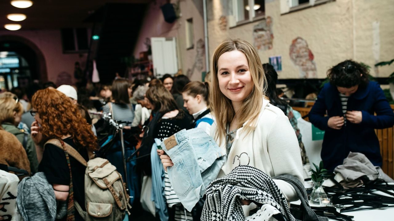 Amalie Talberg holder en bunke med klær som hun har byttet til seg på Den store klesbyttedagen.