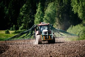 Traktor på jorde sprer gjødsel fra Oslos matavfall
