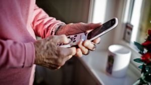 Eldre dame taster på en telefon