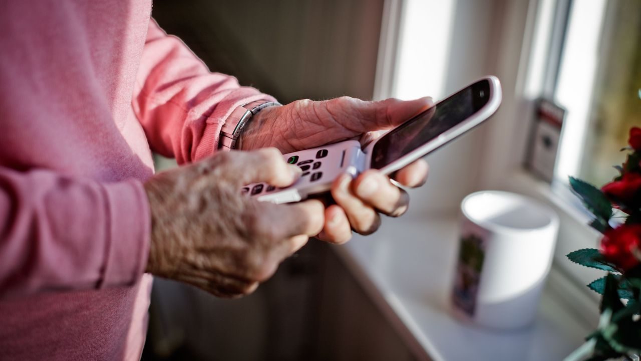 Eldre dame taster på en telefon