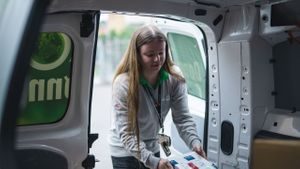 Dame som henter pakker i en varebil