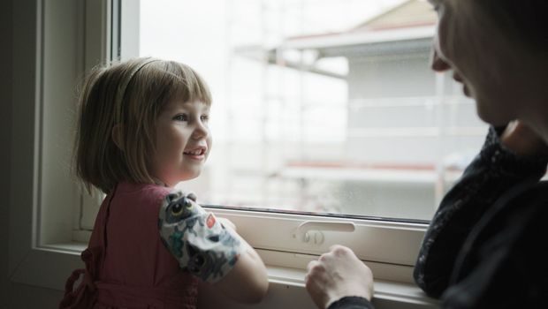 Mor og datter kikker ut av vinduet