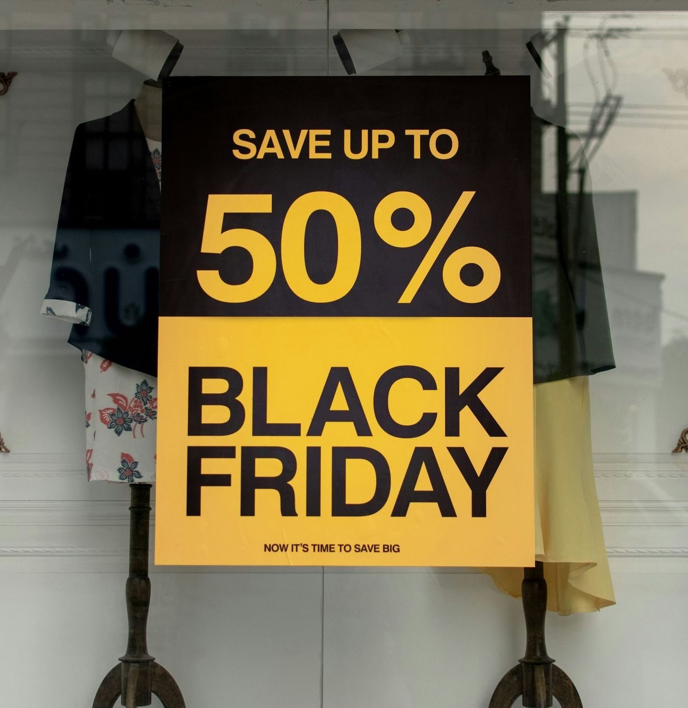 Butikkvindu med Black Friday-plakat. Plakaten viser at det er tilbud med 50% avslag.